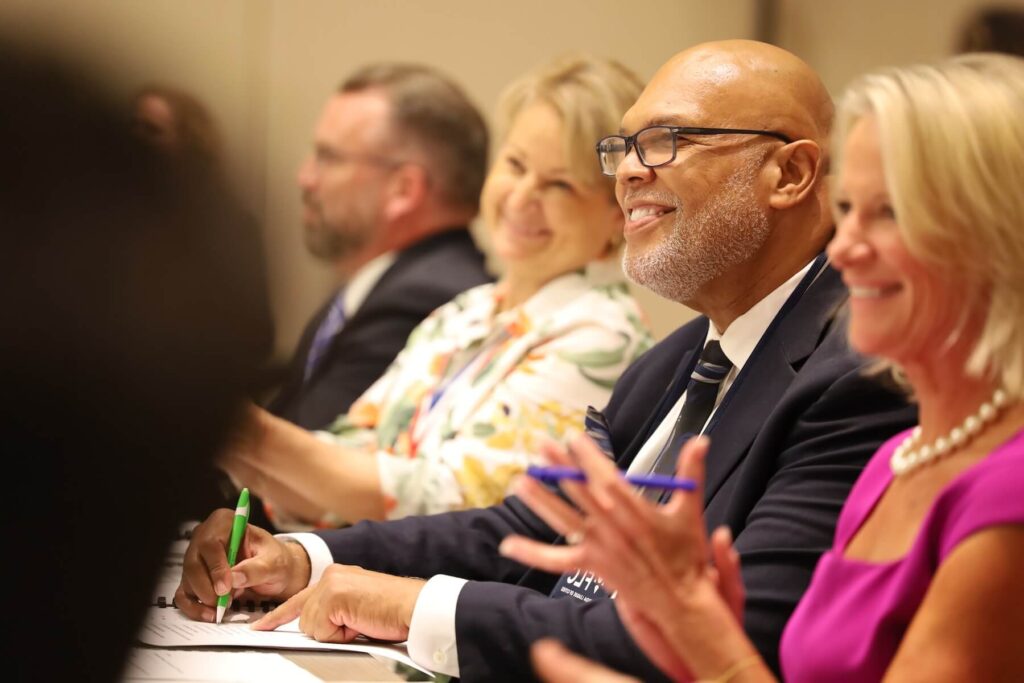 Several individuals on the board of directors applauding.