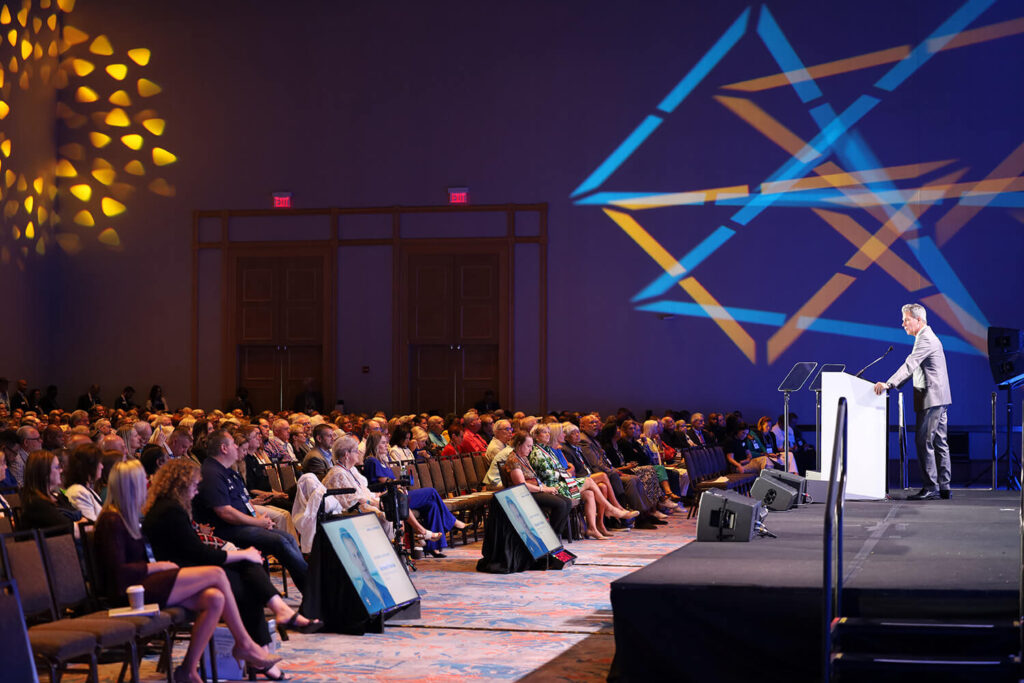Man addressing the crowd from a stage