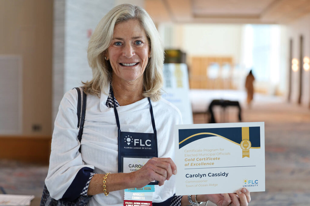 A woman holding her FLC Gold Certificate of Excellence