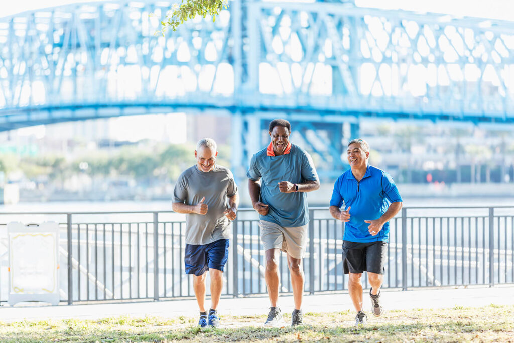 Three men running in an outdoor park