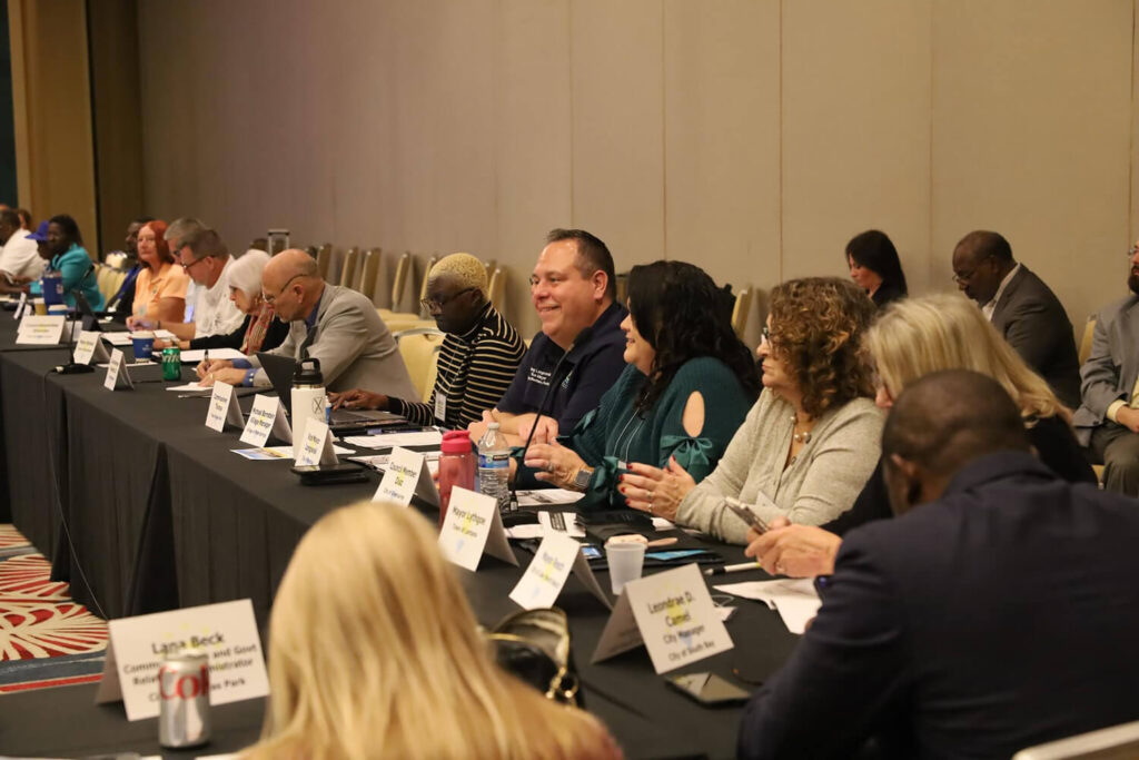 Committee members at a table addressing a crowd